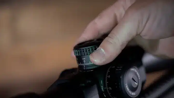 A hand adjusting a thermal scope.